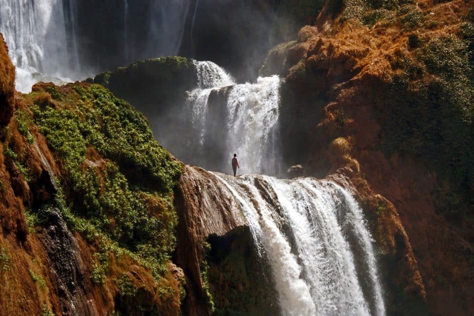 Man stands at the top of a waterfall