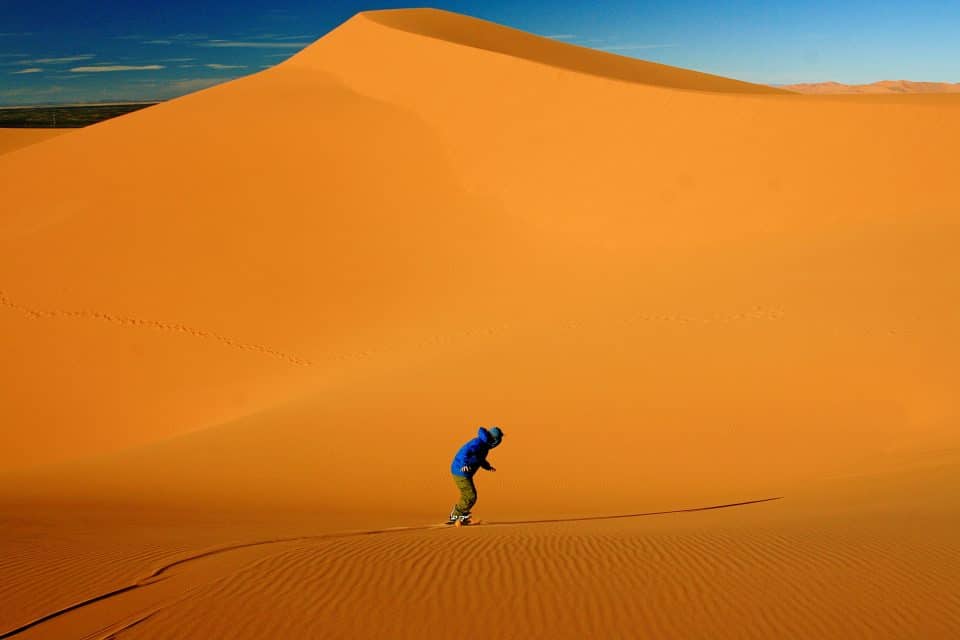 Sandboarder at bottom of sand dune