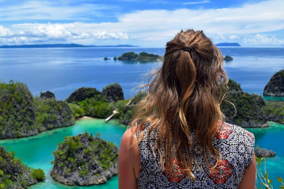 Girl looking out over Piaynemo, Raja Ampat, Indonesia