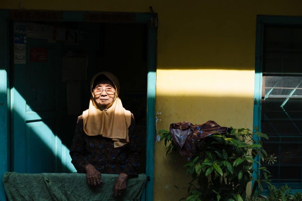Old lady looks out from her house, Yogyakarta, Indonesia