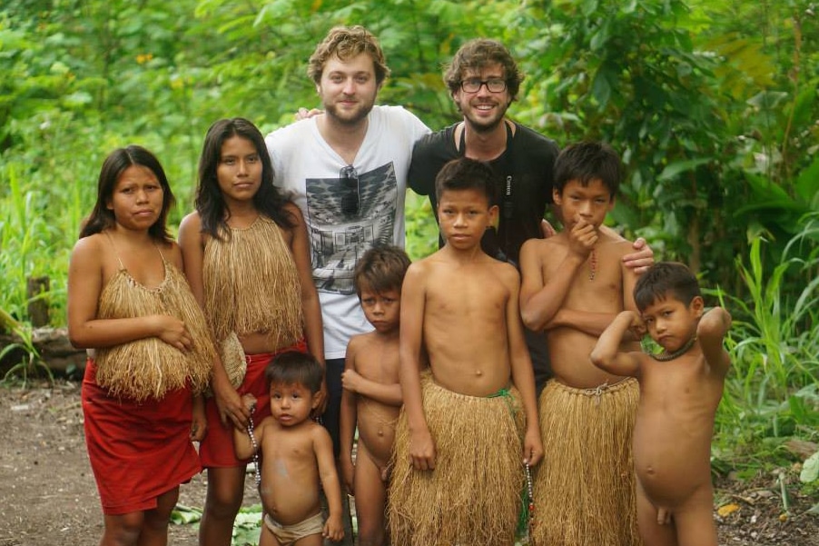 Two guys posing with an Amazonian tribe