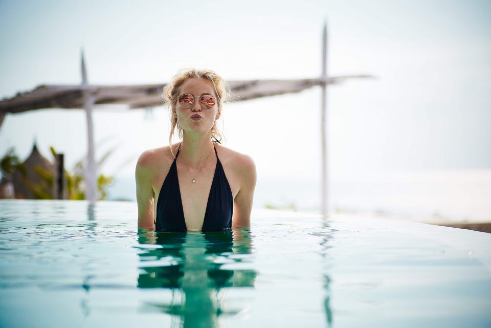 A woman standing in an infinity pool