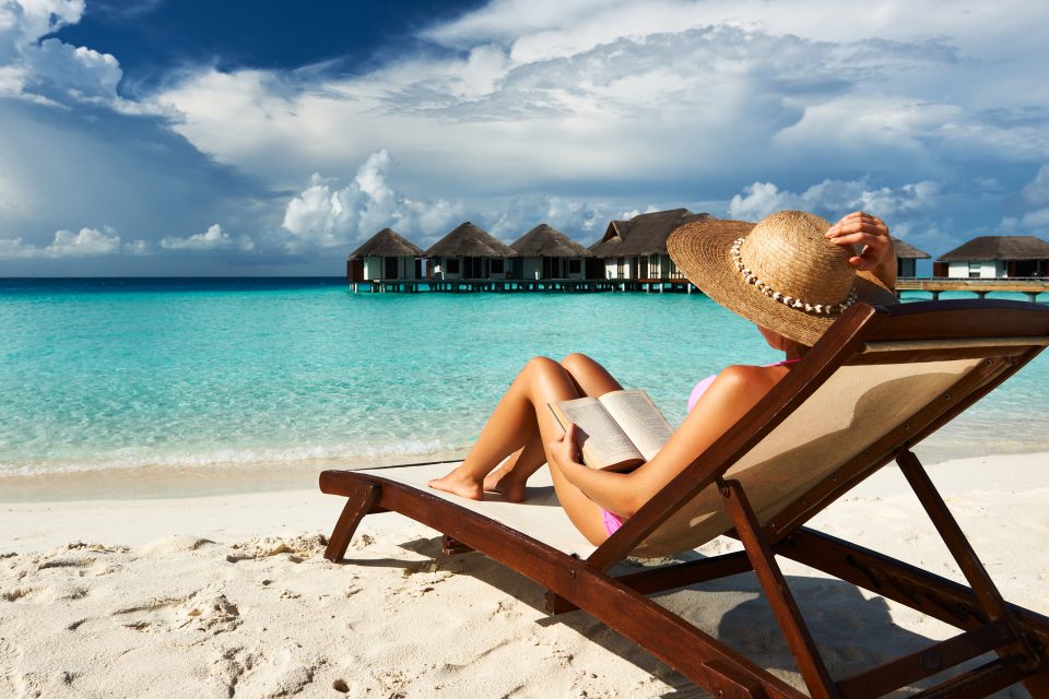 A woman sitting in a deckchair on the beach