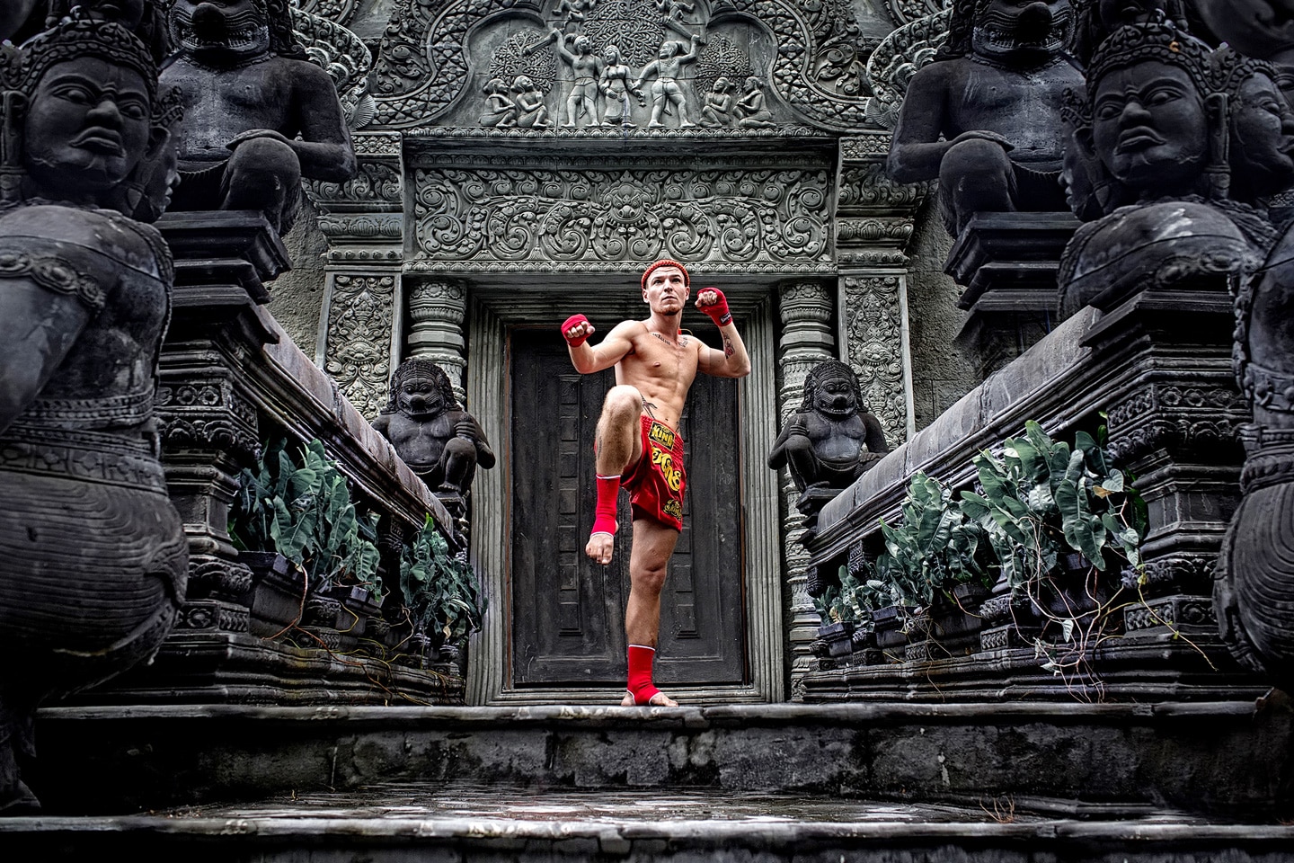 Muay Thai boxer posing outside temple