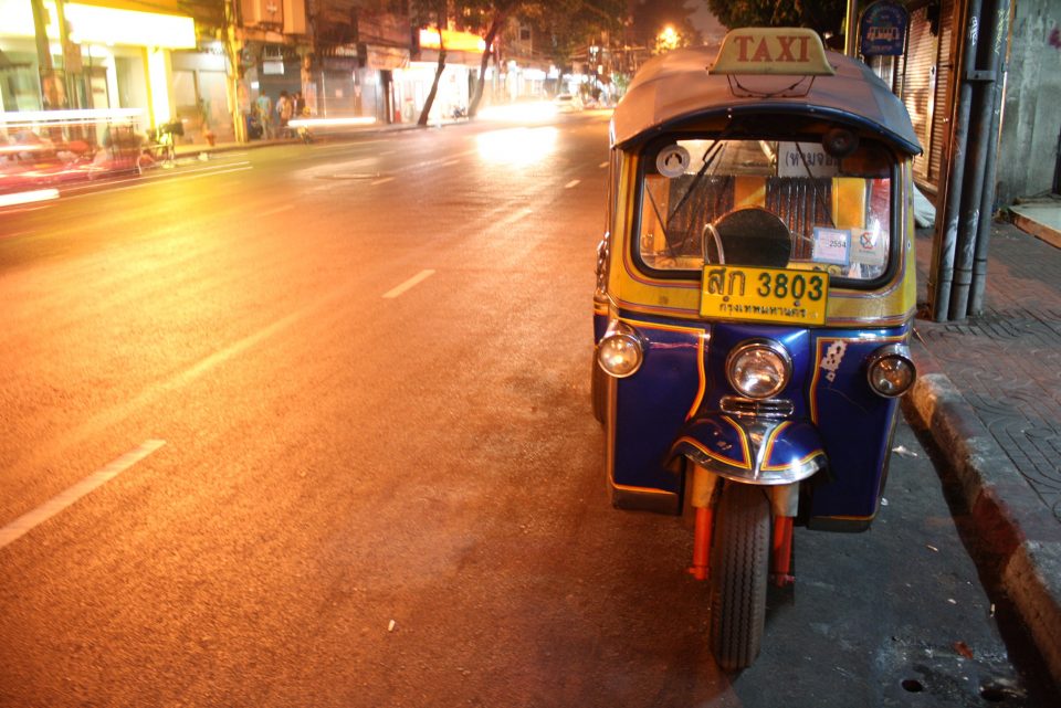 A tuk tuk parked on the side of the road