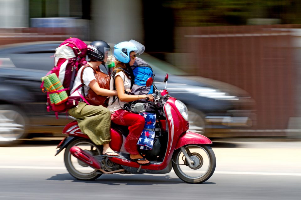 Female backpackers on a motorbike