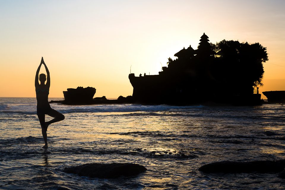 A woman doing yoga in the sea