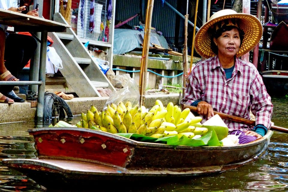 A local woman selling bananas from a canoe