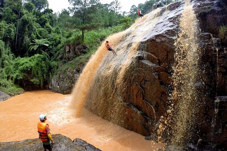 A person abseiling down a waterfall