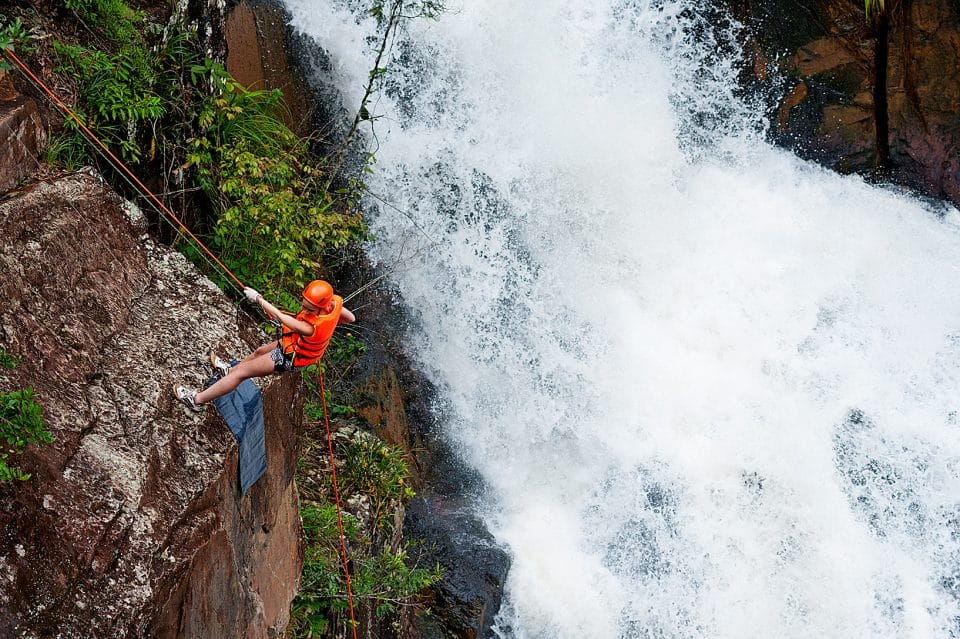 A man abseiling down a waterfall