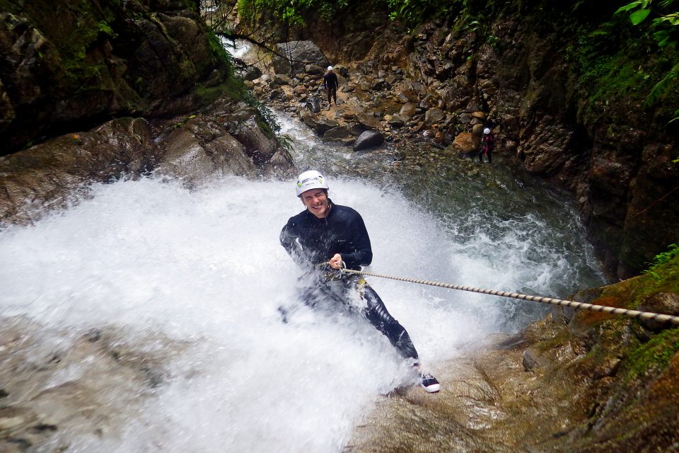 A man abseiling down a waterfall