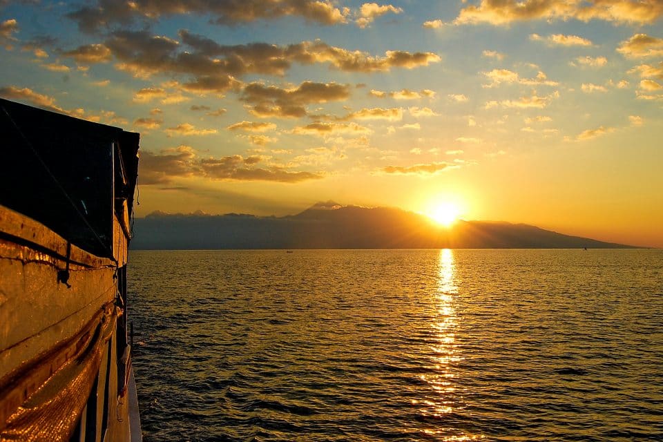 View of a sunset over a mountain from a boat