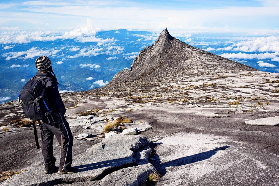 一個男人站在基納巴盧山的山頂