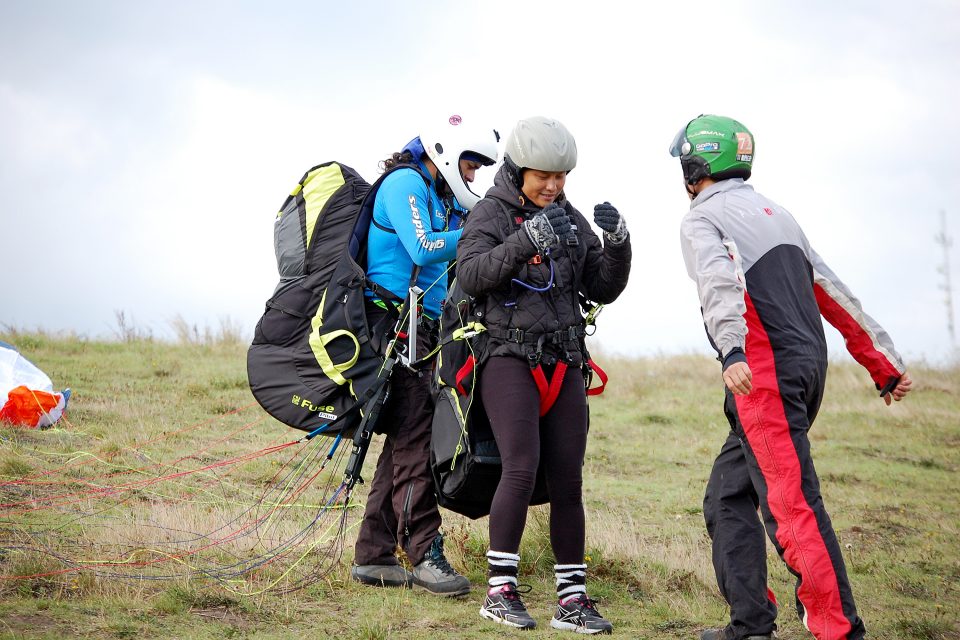 A woman getting geared up for paragliding