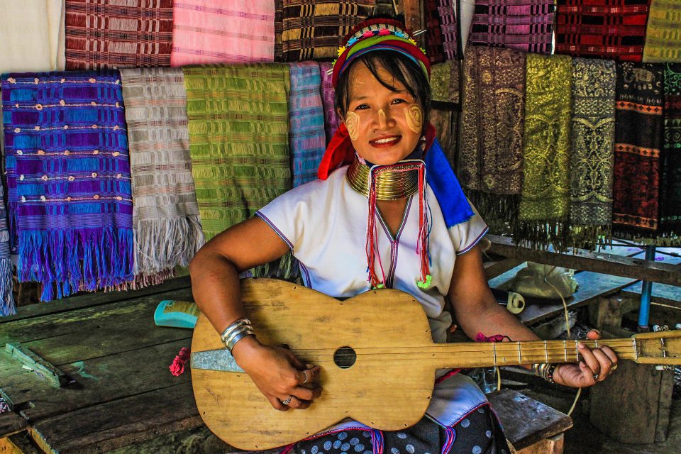 A tribe woman playing a guitar