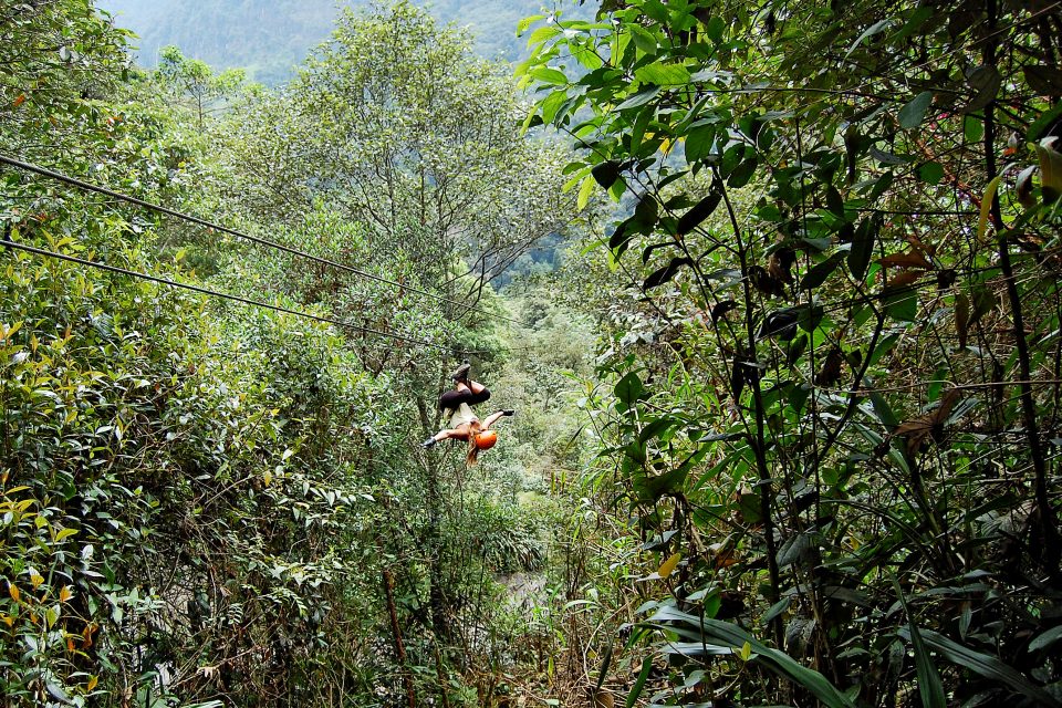 A woman ziplining upside down through the jungle