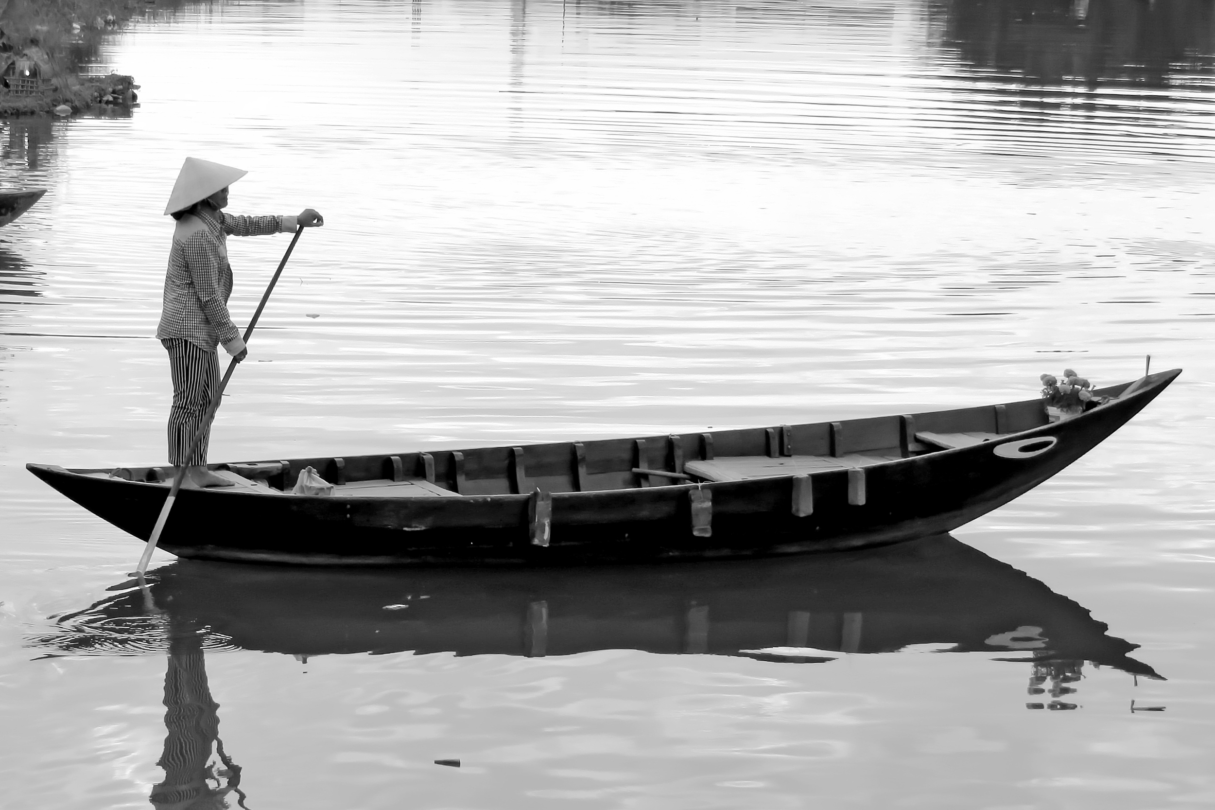 A woman punting a canoe