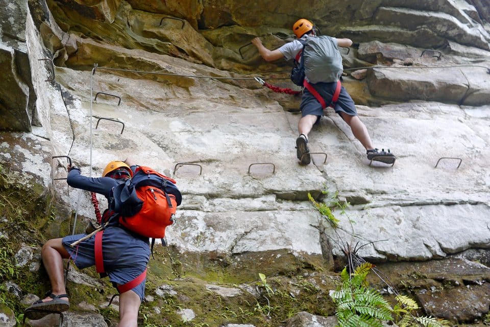 man climbing rocks laos