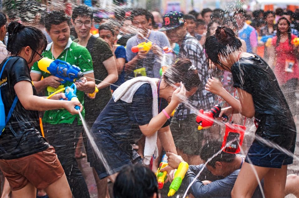 Groups of people squirting each other with water guns
