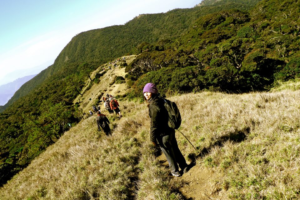 A woman hiking with a group over the mountains
