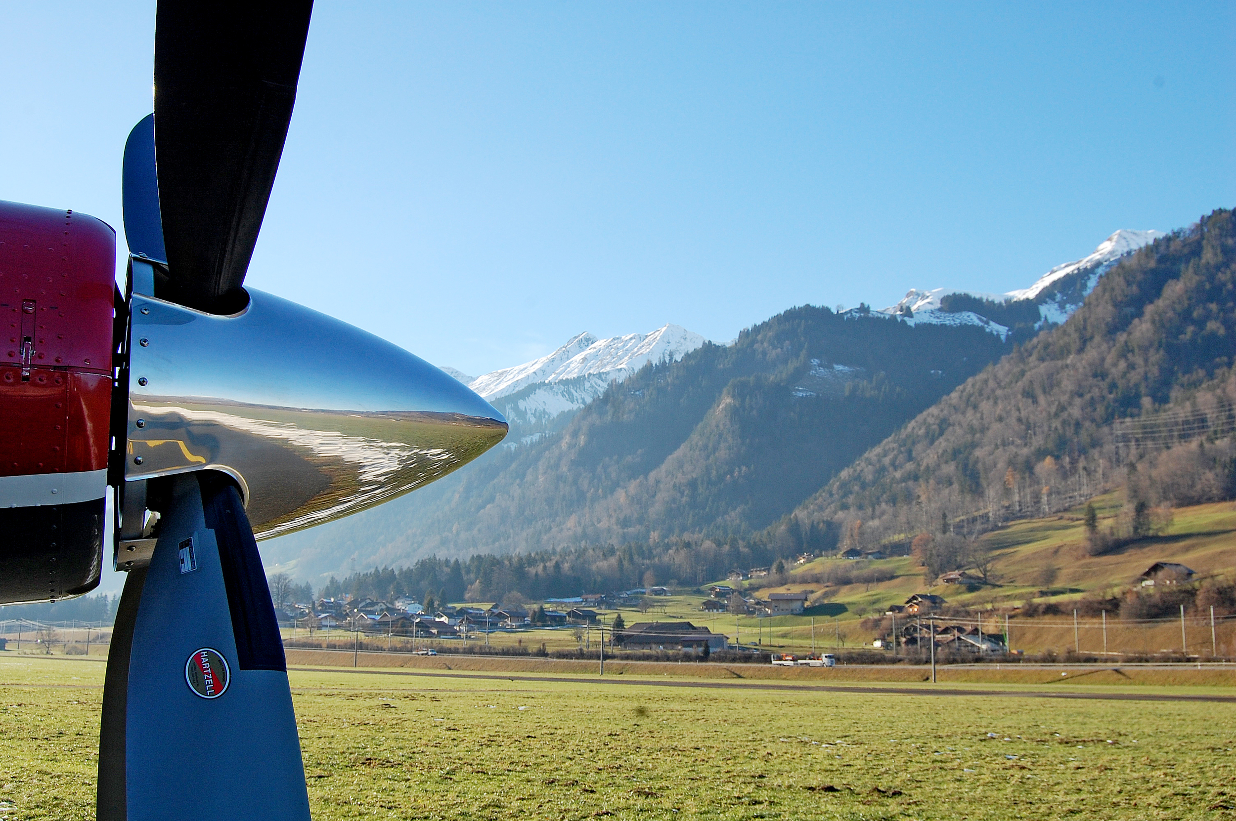 Side shot of a plane propeller and mountains behind 