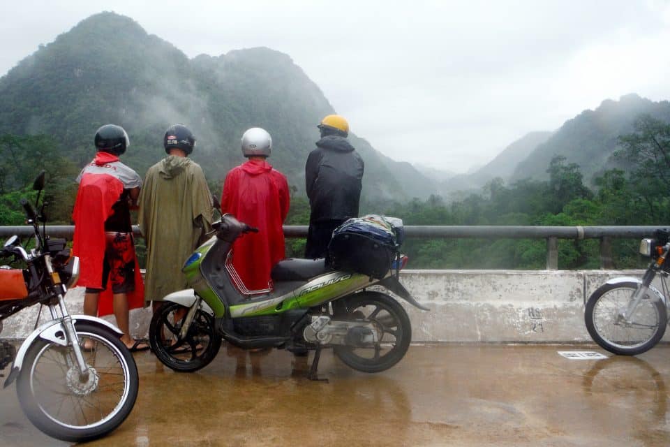 A group of riders looking at mountains in the rain
