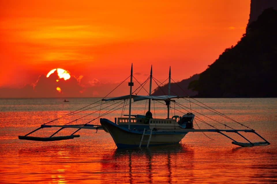 A boat at sea at sunset