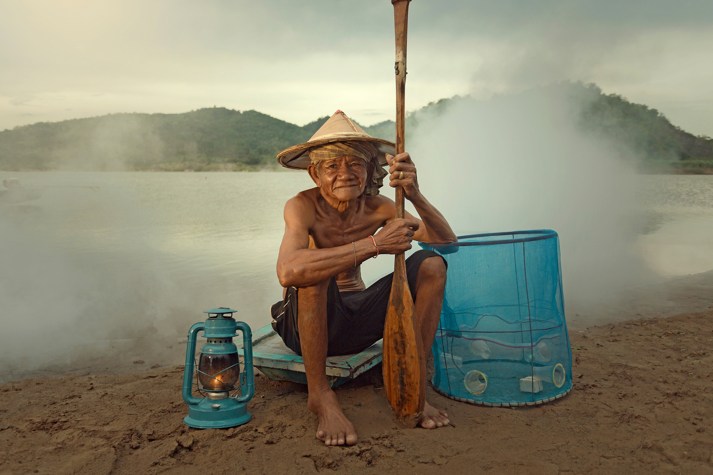 A local fisherman sitting on the ground