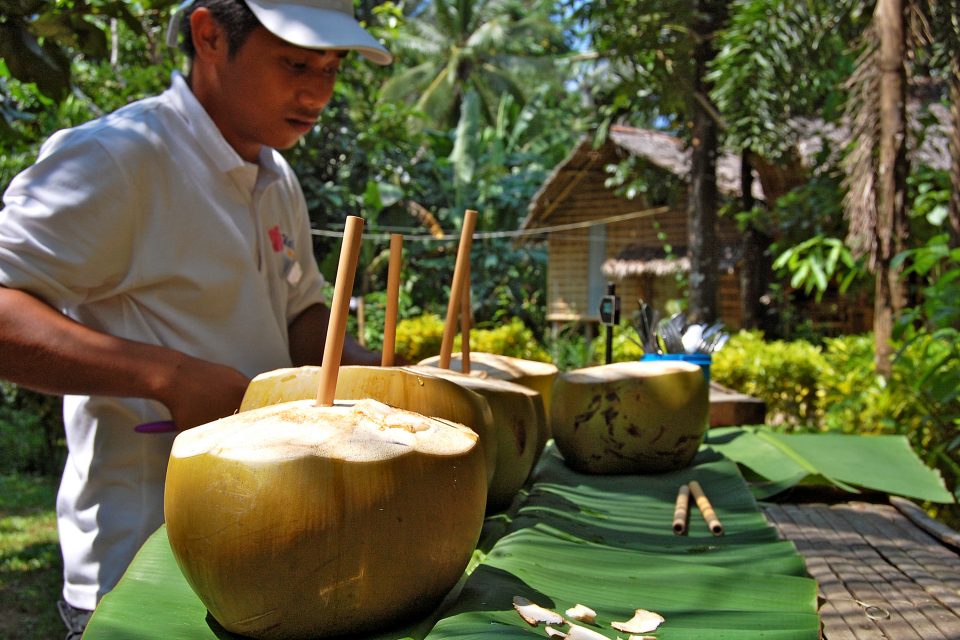 A local man preparing coconut drinks