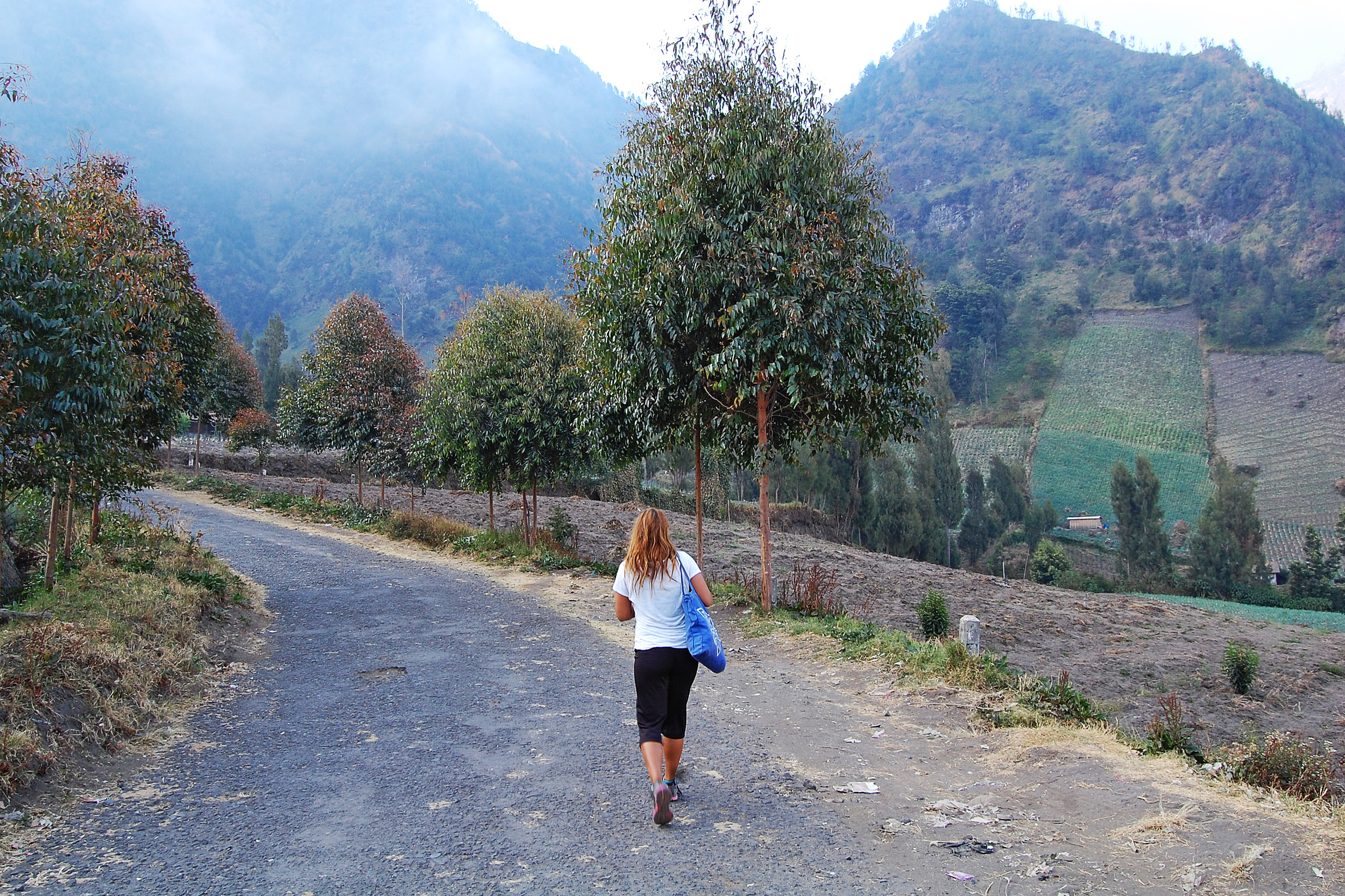 A woman walking down a road on the mountain