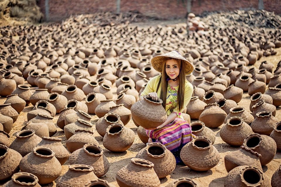 A woman surrounded by clay pots