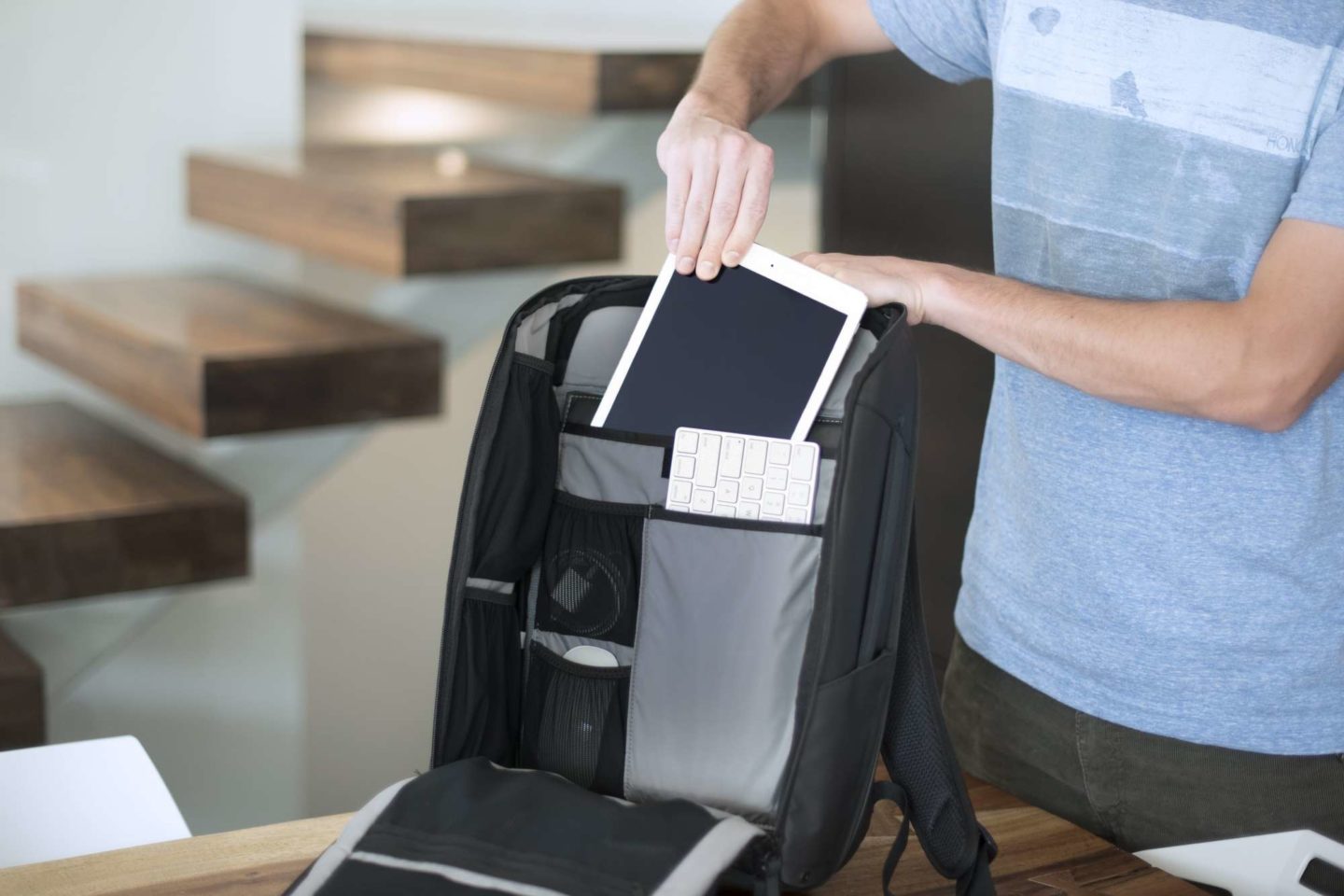 Writer Tom Rogers sliding tablet into nomatic backpack