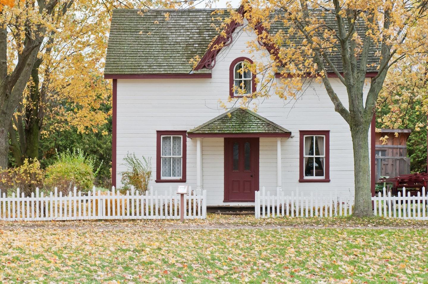 small white house with red door and front yard