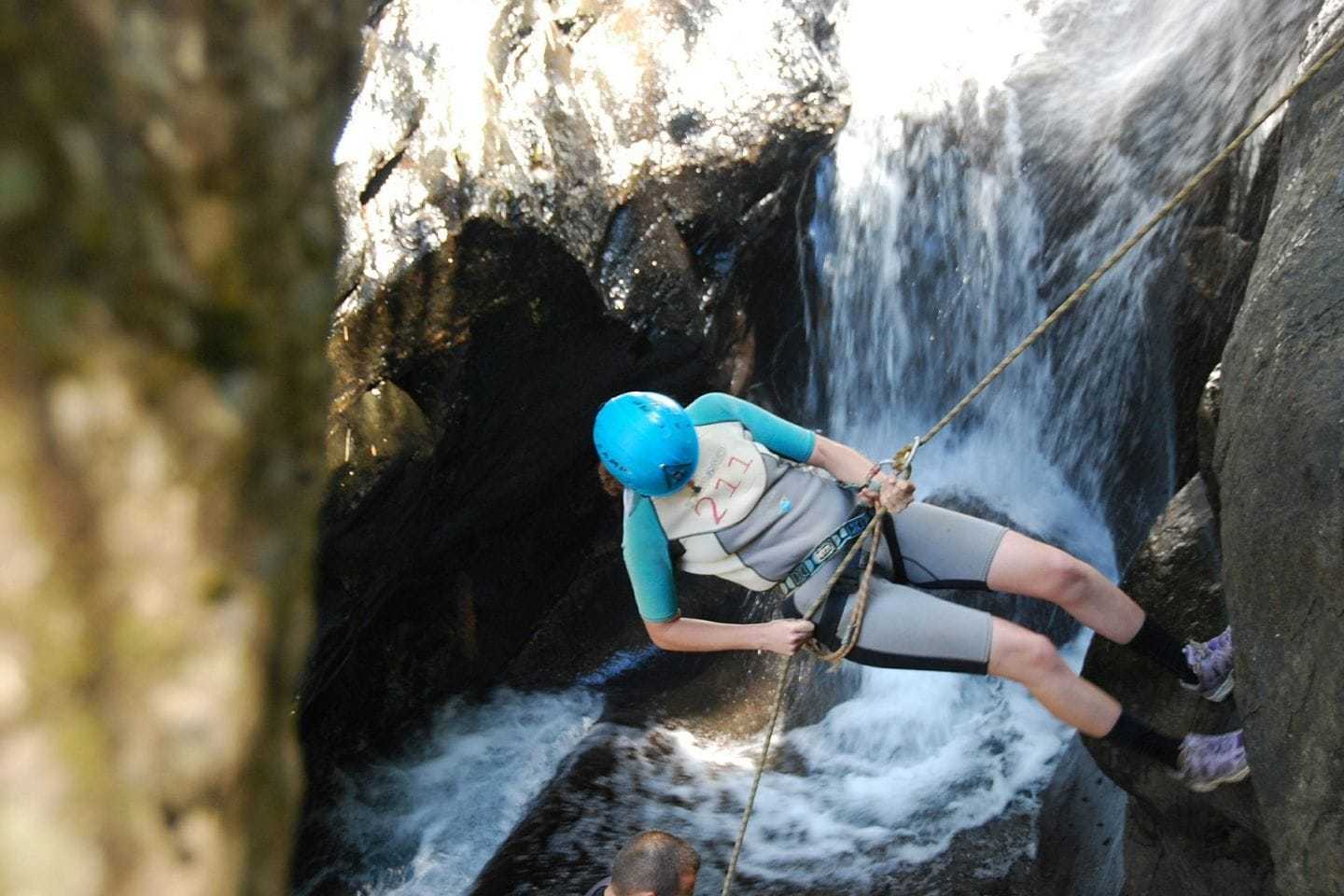 woman canyoning down a waterfall
