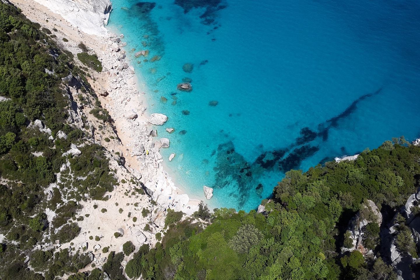 turquoise water with beach and surrounding greenery