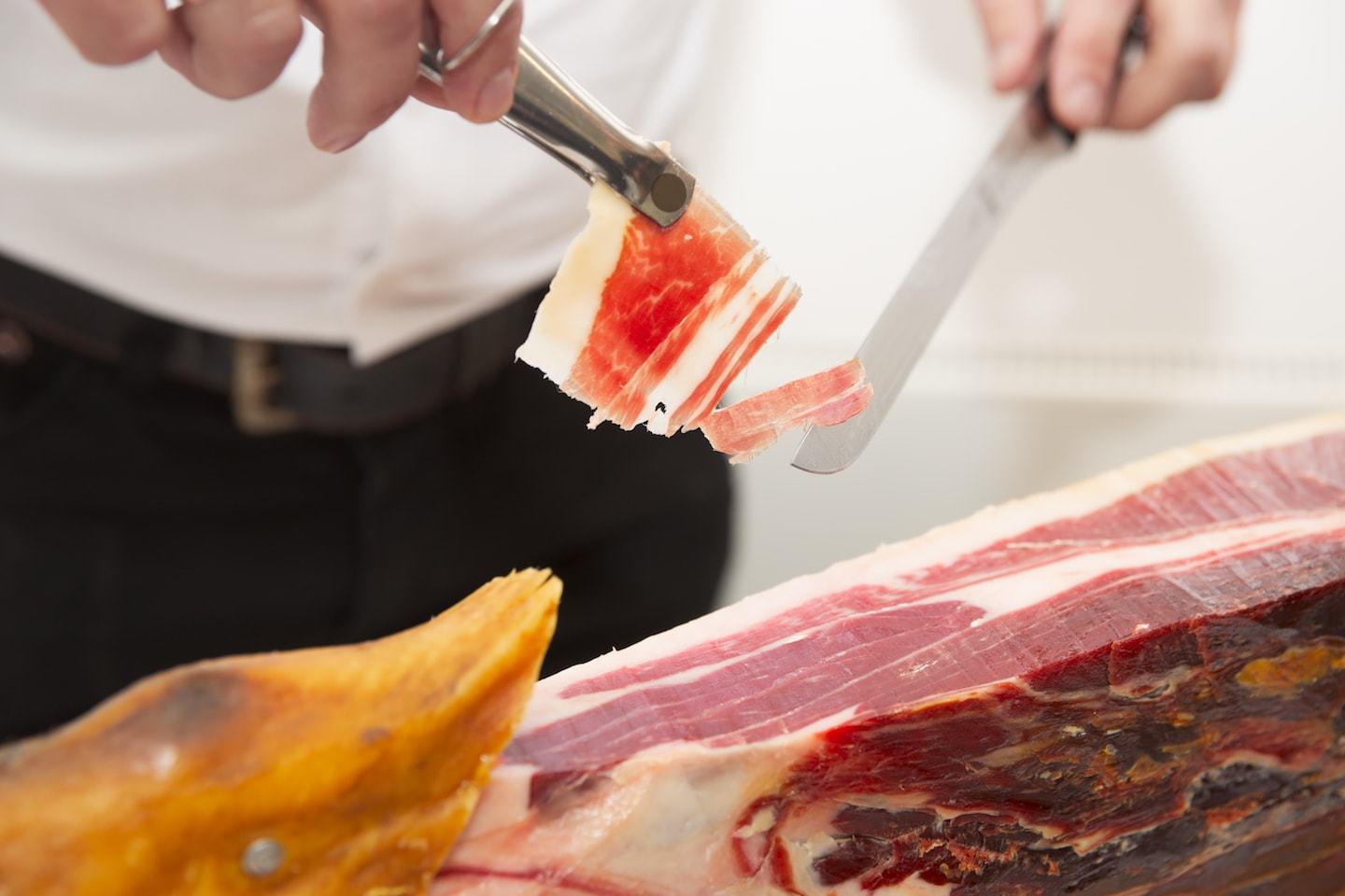 waiter slicing thin cut of ham
