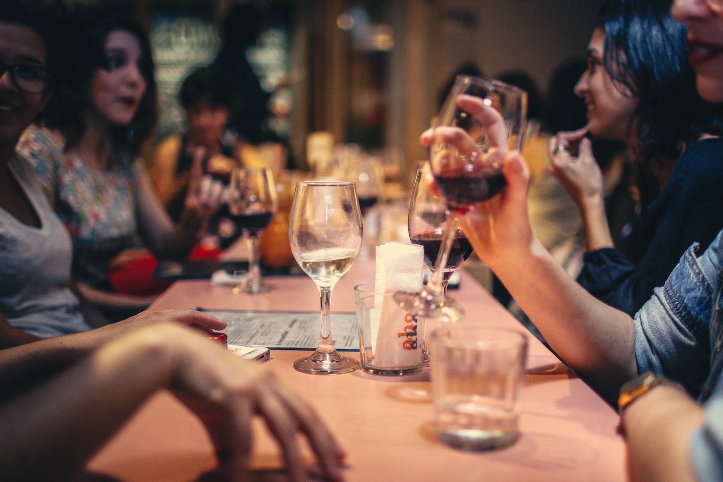 people drinking wine and talking around a restaurant table