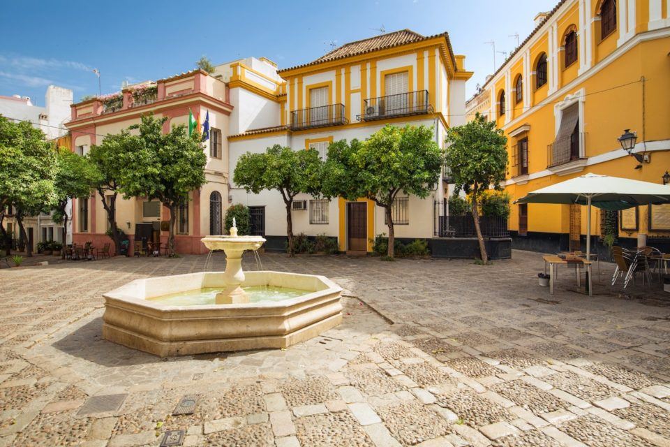 colorful buildings surrounding small town square with fountain