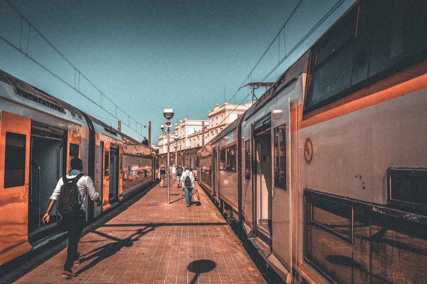 person walking between two trains in spain