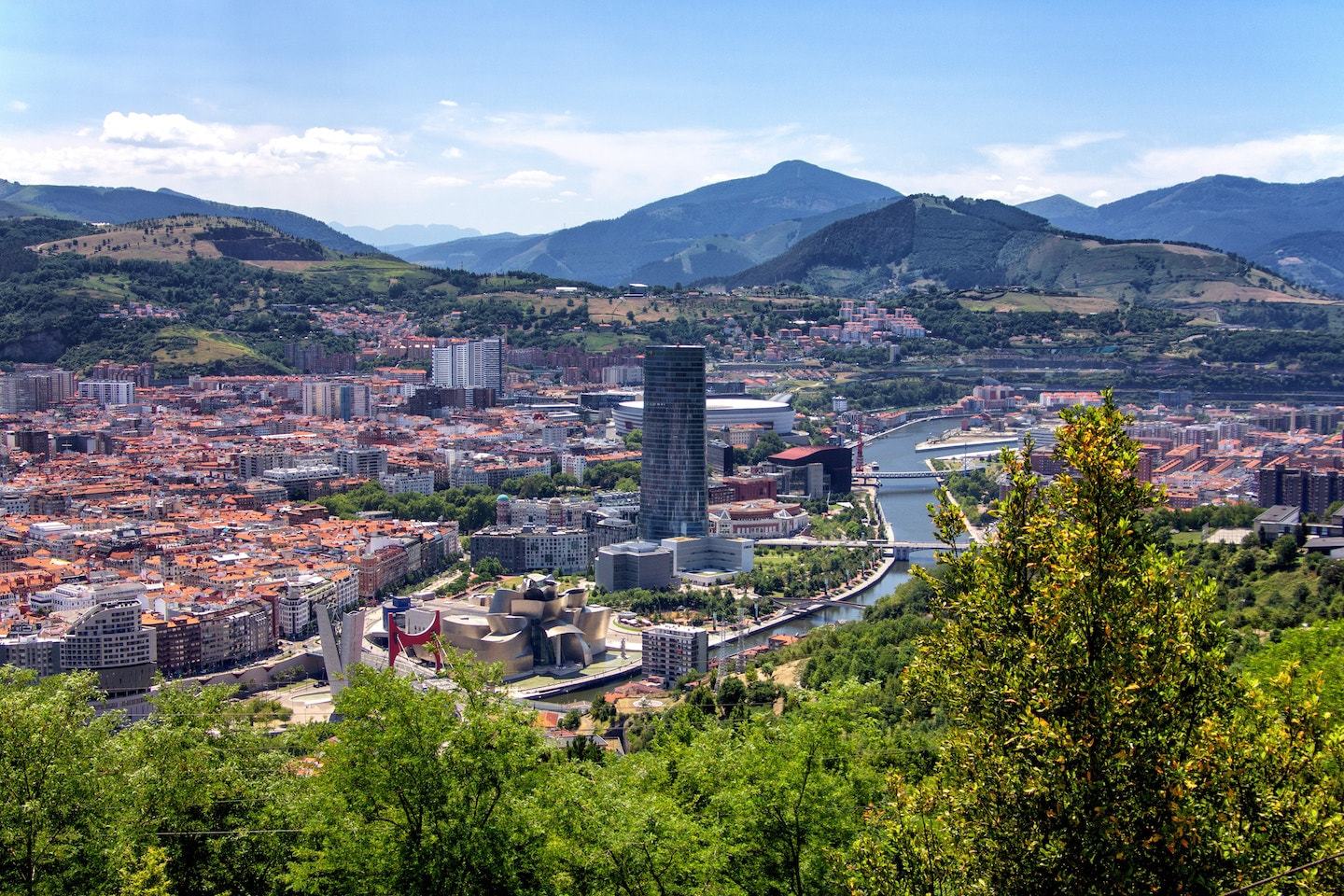 Aerial view of bilbao spain with buildings, trees and mountains