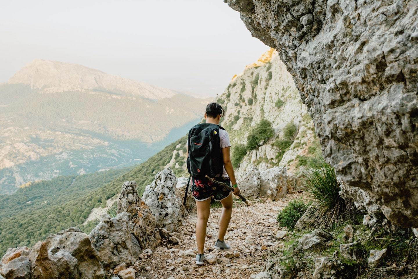 person trekking through rocky mountains in spain