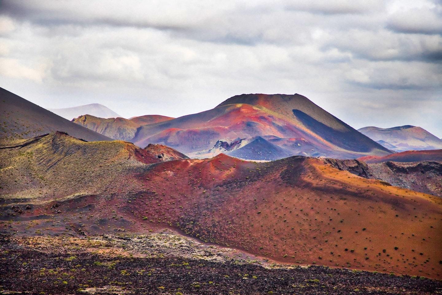 rainbow colored volcanic landscape with cloudy sky