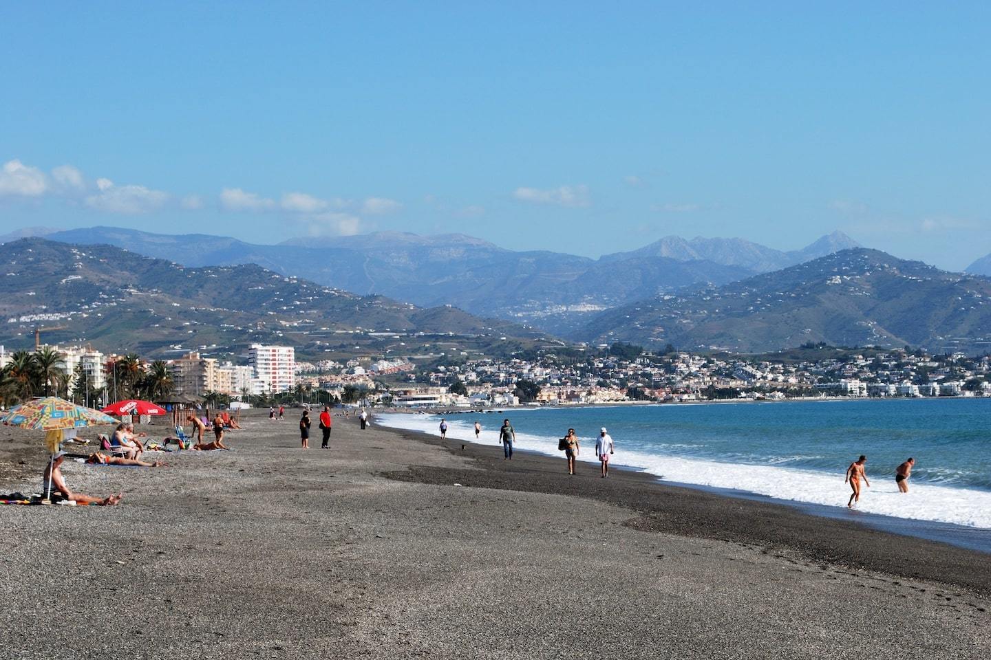 beach with dark sand and mountains behind