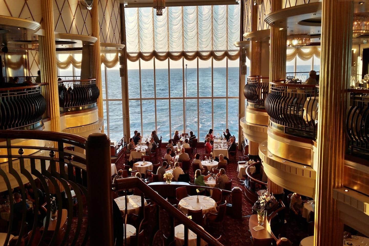 people dining at golden hour on a cruise ship with water outside of the window
