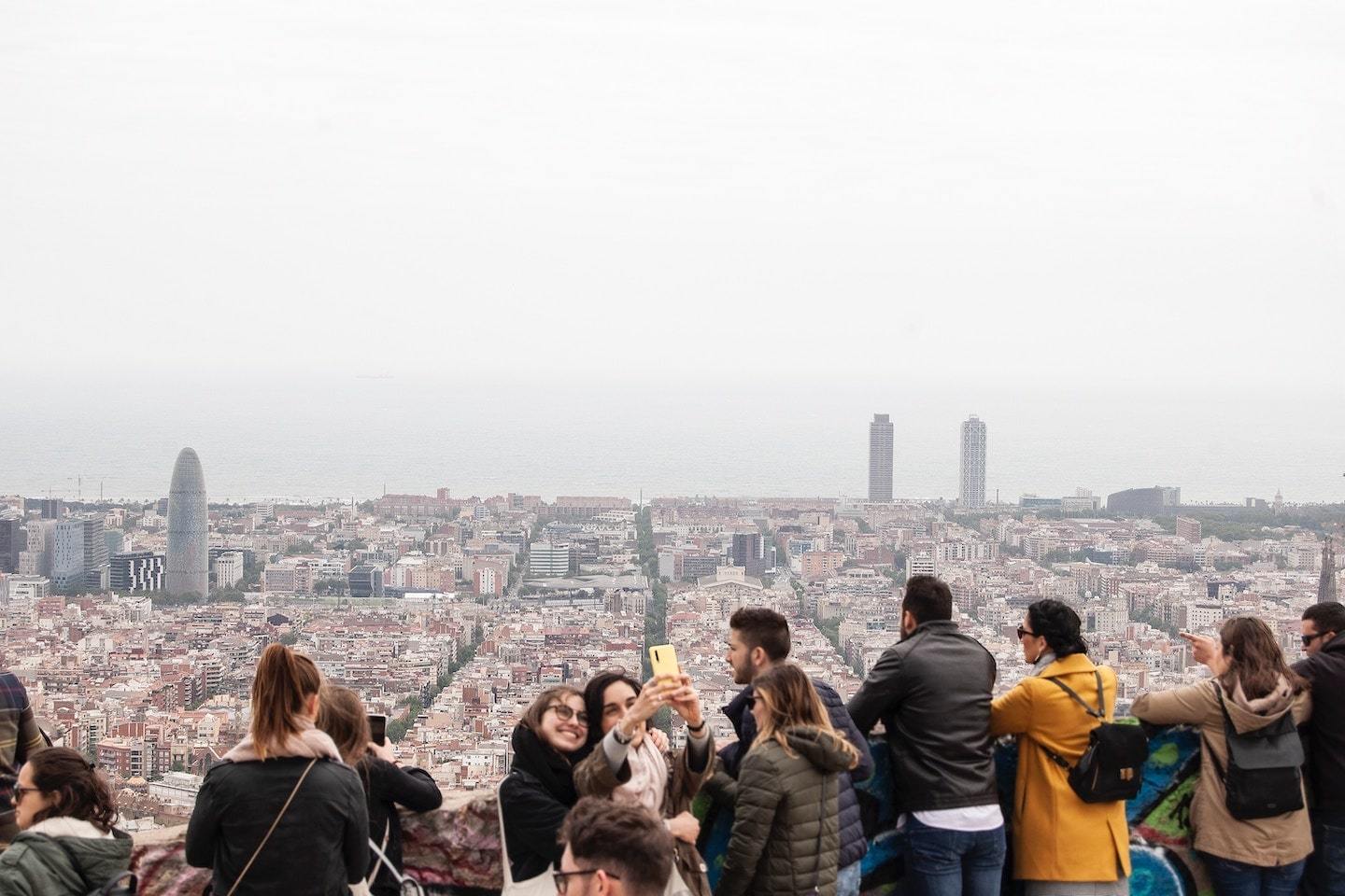 people taking selfies with Barcelona behind