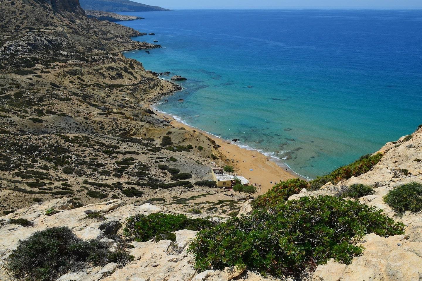 view of beach from above surrounded by rocks, cliffs and the sea in Crete, Greece
