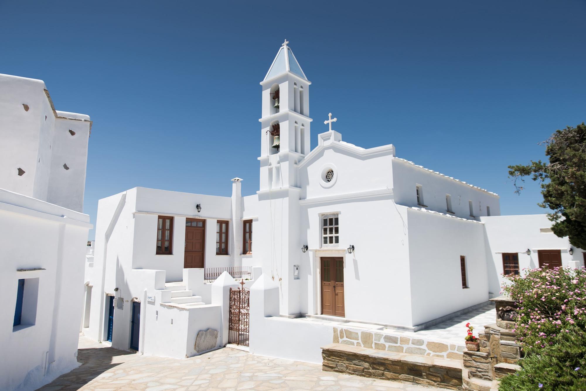 Cyclades Greece: white church with blue sky behind in tinos greece