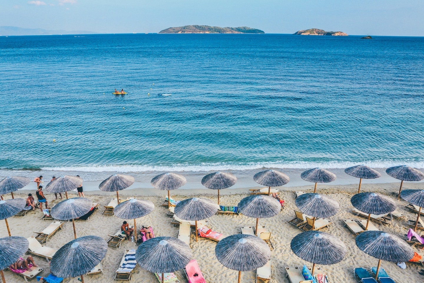 umbrellas lining beach in front of sea in Skiathos greece