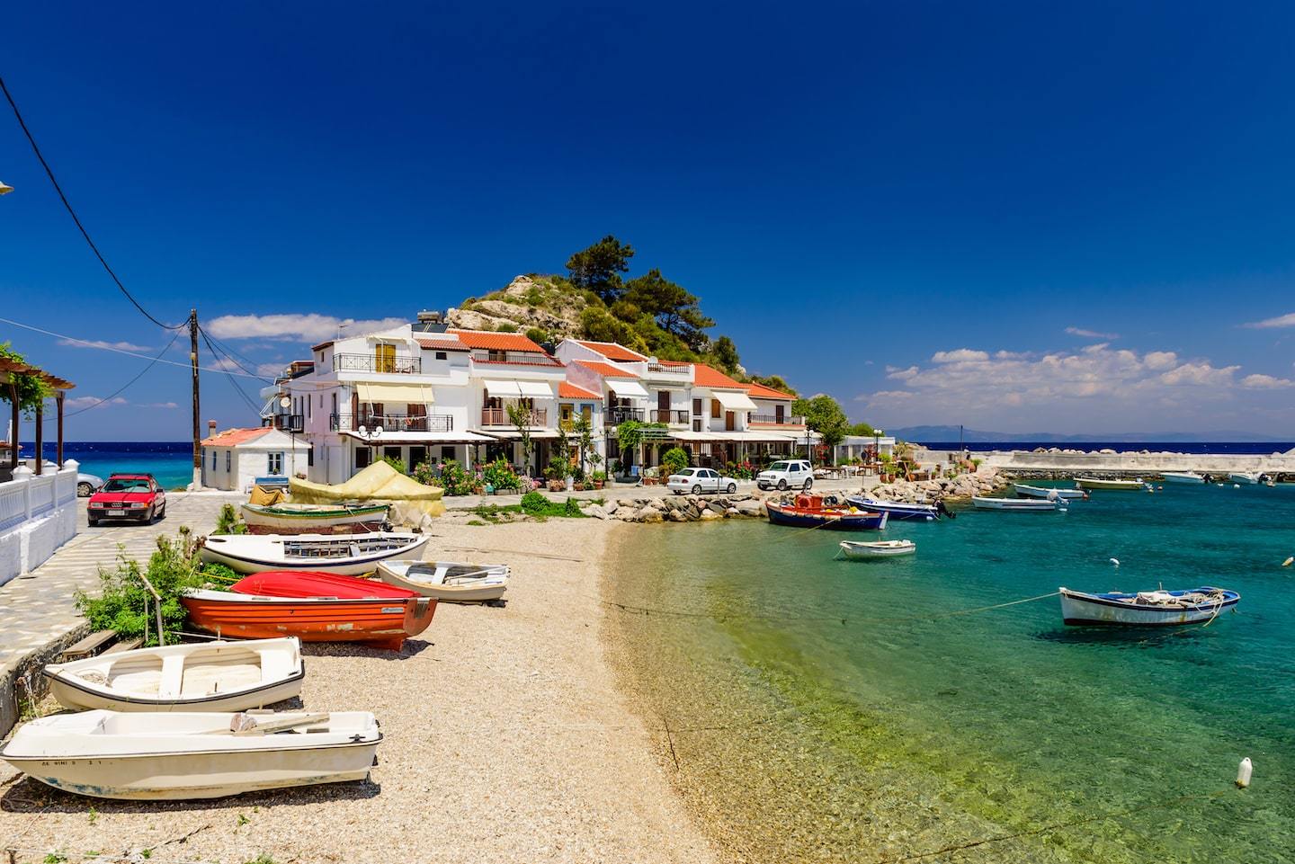 boats on a shore with little town behind in Samos, island in Greece
