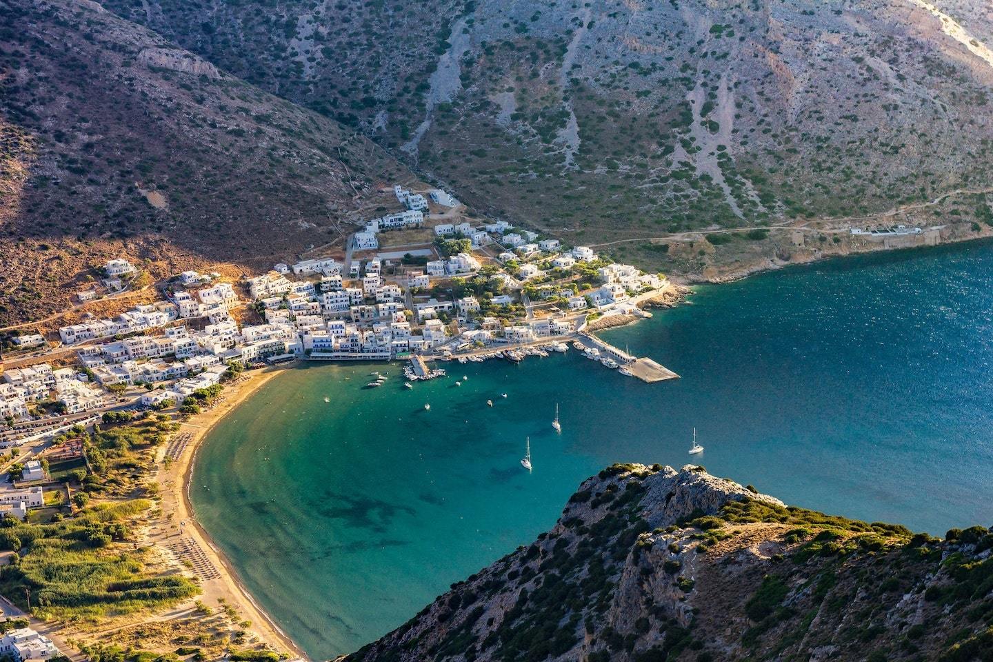 aerial view of bay with beach and houses surrounded by mountains in Sifnos greece